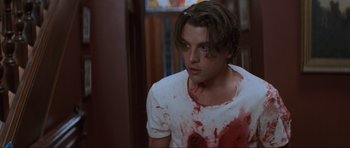 Movie still from “Scream” (1996), directed by Wes Craven – A young man with blood all over his face; Close Up shot, Low angle