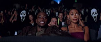 Movie still from “Scream 2” (1997), directed by Wes Craven – A group of people sitting in front of an audience; Medium shot, High angle