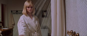 Movie still from “Scream 2” (1997), directed by Wes Craven – A woman standing in front of a window wearing a robe; Close Up shot, Over the shoulder angle