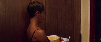 Movie still from “Scream 2” (1997), directed by Wes Craven – A woman sitting at a table with a bowl of macaroni and cheese; Medium shot, Over the shoulder angle