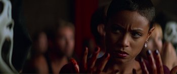 Movie still from “Scream 2” (1997), directed by Wes Craven – A woman with her hand up in the air; Close Up shot, Over the shoulder angle
