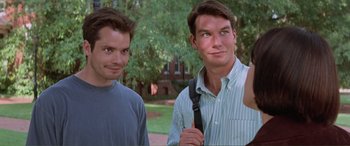 Movie still from “Scream 2” (1997), directed by Wes Craven – Two men standing next to each other on a field; Close Up shot, Over the shoulder angle