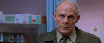 Movie still from “Scream 2” (1997), directed by Wes Craven – An older man in a green jacket looking at the camera; Close Up shot, Low angle