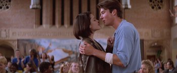 Movie still from “Scream 2” (1997), directed by Wes Craven – A man and a woman kissing in front of a group of people; Medium shot, Low angle