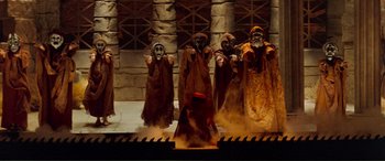 Movie still from “Scream 2” (1997), directed by Wes Craven – A group of people dressed in brown and orange costumes; Wide shot, High angle