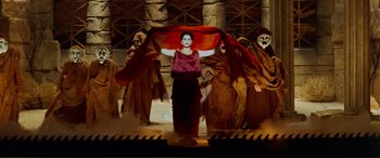 Movie still from “Scream 2” (1997), directed by Wes Craven – A woman holding an umbrella while standing in front of a group of people; Wide shot, Low angle