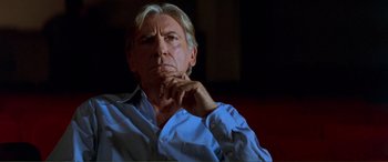 Movie still from “Scream 2” (1997), directed by Wes Craven – An older man in a blue shirt is sitting with his hand under his chin; Close Up shot, Low angle