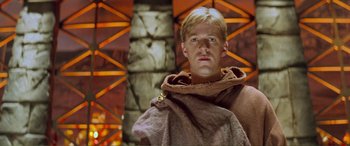 Movie still from “Scream 2” (1997), directed by Wes Craven – A man wearing a brown robe and holding a brown blanket; Close Up shot, Low angle