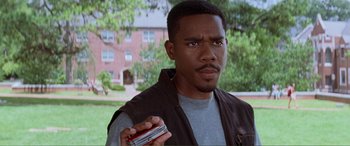 Movie still from “Scream 2” (1997), directed by Wes Craven – A man holding two cell phones in his hands; Close Up shot, High angle