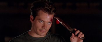 Movie still from “Scream 2” (1997), directed by Wes Craven – A man holding a knife with blood all over his face; Close Up shot, Over the shoulder angle