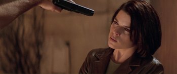 Movie still from “Scream 2” (1997), directed by Wes Craven – A woman holding a remote control in front of her face; Close Up shot, Over the shoulder angle