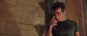 Movie still from “Scream 2” (1997), directed by Wes Craven – A man with a blood soaked face holding his hand to his face; Close Up shot, High angle