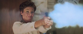 Movie still from “Scream 2” (1997), directed by Wes Craven – A woman holding a gun in her right hand; Close Up shot, Low angle