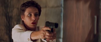 Movie still from “Scream 2” (1997), directed by Wes Craven – A woman is holding a gun in her hand; Close Up shot, Low angle