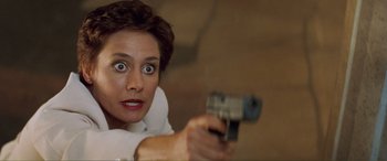 Movie still from “Scream 2” (1997), directed by Wes Craven – A woman is holding a gun up to her face; Close Up shot, High angle