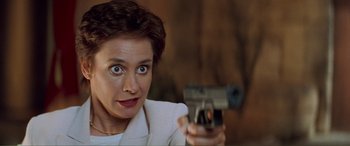 Movie still from “Scream 2” (1997), directed by Wes Craven – A woman is holding a gun up to her face; Close Up shot, Over the shoulder angle