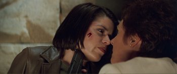 Movie still from “Scream 2” (1997), directed by Wes Craven – A person holding a gun in their face; Close Up shot, Over the shoulder angle