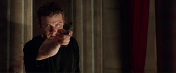 Movie still from “Scream 2” (1997), directed by Wes Craven – A man holding a gun in his right hand; Close Up shot, Low angle