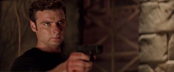 Movie still from “Scream 2” (1997), directed by Wes Craven – A man is holding a gun in his hand; Close Up shot, Low angle