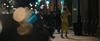 Movie still from “Scream VI” (2023), directed by Matt Bettinelli-Olpin – A woman in a yellow dress talking on a cell phone; Wide shot, Low angle