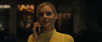 Movie still from “Scream VI” (2023), directed by Matt Bettinelli-Olpin – A woman in a yellow shirt is talking on a cell phone; Close Up shot, Low angle
