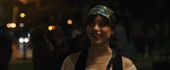 Movie still from “Scream VI” (2023), directed by Matt Bettinelli-Olpin – A young woman wearing a colorful head scarf; Close Up shot, Over the shoulder angle
