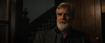 Movie still from “Scream VI” (2023), directed by Matt Bettinelli-Olpin – An older man with a beard and a suit; Close Up shot, Over the shoulder angle