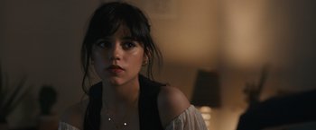 Movie still from “Scream VI” (2023), directed by Matt Bettinelli-Olpin – A young woman with long black hair wearing a white top; Close Up shot, Over the shoulder angle