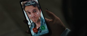 Movie still from “Scream VI” (2023), directed by Matt Bettinelli-Olpin – A person holding up a cell phone to take a picture; Extreme Close Up shot, Overhead angle