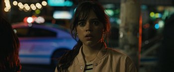 Movie still from “Scream VI” (2023), directed by Matt Bettinelli-Olpin – A young woman is standing in the dark; Close Up shot, Over the shoulder angle