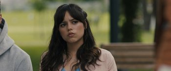 Movie still from “Scream VI” (2023), directed by Matt Bettinelli-Olpin – A woman with long black hair wearing a pink jacket; Close Up shot, Over the shoulder angle