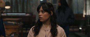 Movie still from “Scream VI” (2023), directed by Matt Bettinelli-Olpin – A woman with long black hair looking to her left; Close Up shot, Over the shoulder angle