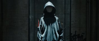 Movie still from “Scream VI” (2023), directed by Matt Bettinelli-Olpin – A person in a hooded sweatshirt holding a bloody knife; Medium shot, Low angle