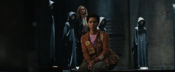 Movie still from “Scream VI” (2023), directed by Matt Bettinelli-Olpin – A group of people standing in a dark room; Medium shot, Over the shoulder angle