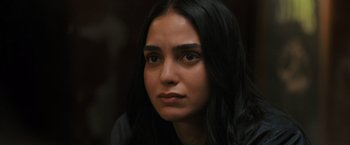 Movie still from “Scream VI” (2023), directed by Matt Bettinelli-Olpin – A person with long black hair; Close Up shot, Over the shoulder angle