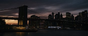 Movie still from “Scream VI” (2023), directed by Matt Bettinelli-Olpin – A view of a city skyline at night with a bridge lit up in the dark; Extreme Wide shot, High angle