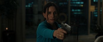 Movie still from “Scream VI” (2023), directed by Matt Bettinelli-Olpin – A woman is holding a gun in her hand; Close Up shot, High angle