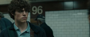 Movie still from “Scream VI” (2023), directed by Matt Bettinelli-Olpin – A young man standing in front of a brick wall; Close Up shot, Over the shoulder angle