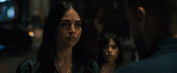 Movie still from “Scream VI” (2023), directed by Matt Bettinelli-Olpin – A woman standing next to another woman in a dark room; Close Up shot, Over the shoulder angle