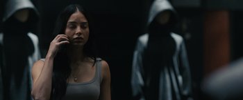 Movie still from “Scream VI” (2023), directed by Matt Bettinelli-Olpin – A woman standing in front of a hooded figure; Medium shot, Over the shoulder angle