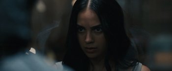 Movie still from “Scream VI” (2023), directed by Matt Bettinelli-Olpin – A person with long black hair; Close Up shot, Over the shoulder angle