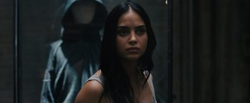 Movie still from “Scream VI” (2023), directed by Matt Bettinelli-Olpin – A woman with long black hair is looking at the camera; Close Up shot, Over the shoulder angle