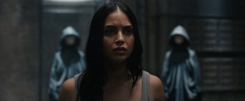 Movie still from “Scream VI” (2023), directed by Matt Bettinelli-Olpin – A woman with long black hair is looking at the camera; Close Up shot, Over the shoulder angle