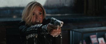 Movie still from “Scream VI” (2023), directed by Matt Bettinelli-Olpin – A woman is pointing a gun at the camera; Close Up shot, Over the shoulder angle