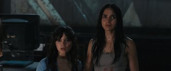 Movie still from “Scream VI” (2023), directed by Matt Bettinelli-Olpin – Two young women standing next to each other in a dark room; Close Up shot, Low angle