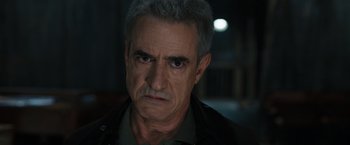 Movie still from “Scream VI” (2023), directed by Matt Bettinelli-Olpin – An older man with grey hair stares at the camera; Close Up shot, Over the shoulder angle