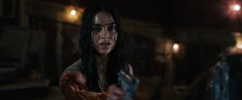 Movie still from “Scream VI” (2023), directed by Matt Bettinelli-Olpin – A woman holding a gun in a dark room; Close Up shot, Over the shoulder angle