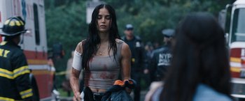 Movie still from “Scream VI” (2023), directed by Matt Bettinelli-Olpin – A woman with a bandage on her arm is walking down the street; Close Up shot, Over the shoulder angle