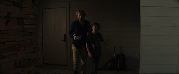 Movie still from “Secret Headquarters” (2022), directed by Henry Joost – A man and a boy are standing in a room; Medium shot, Low angle
