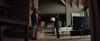 Movie still from “Secret Headquarters” (2022), directed by Henry Joost – Two people standing in front of a fire place; Wide shot, Low angle